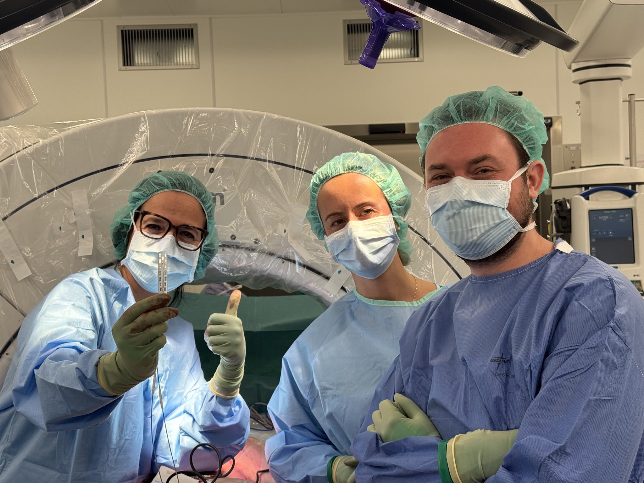 Surgeons smiling at the camera after a successful neural implant surgery.