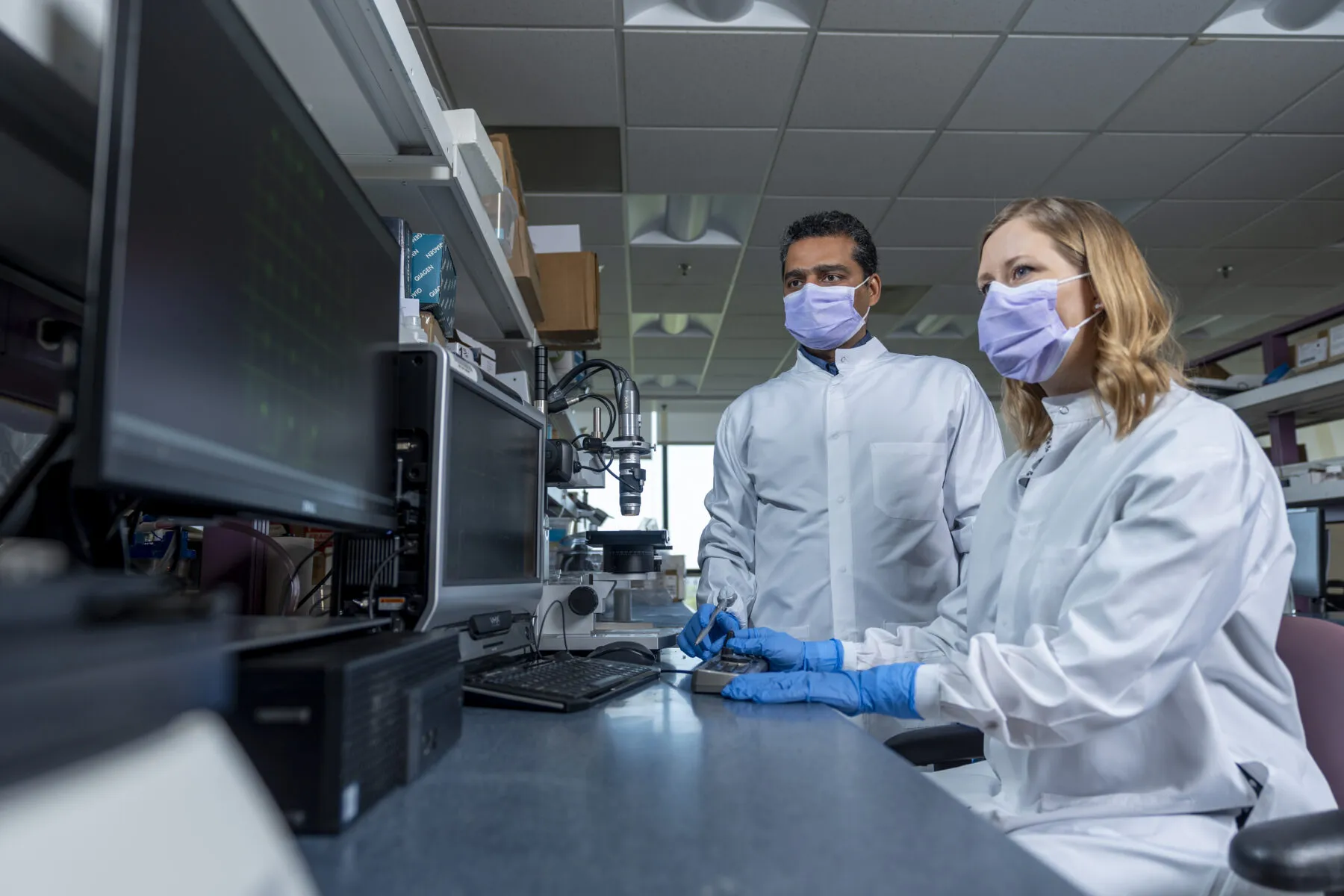 NexTGen team looking at a computer screen in lab