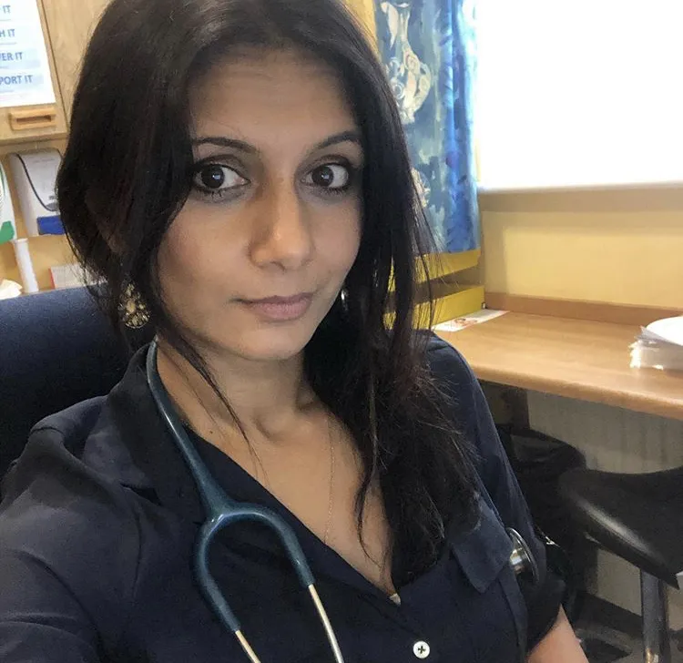Anisha in her GP surgery. She has a stethoscope around her neck.