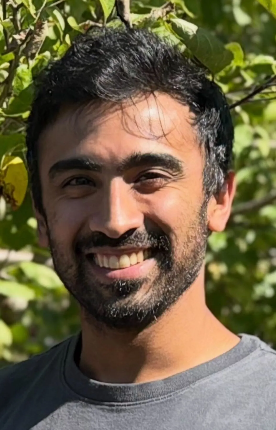Dr Surya Nagaraja, Harvard University postdoctoral fellow, smiling in front of trees