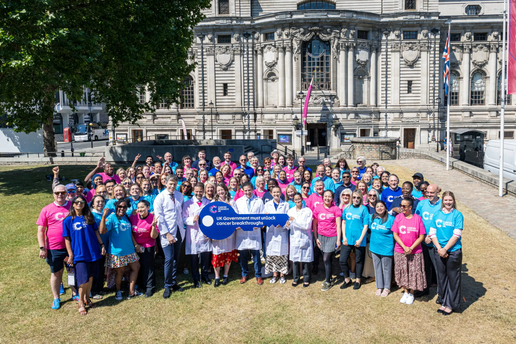 People stand outside parliament holding a key.