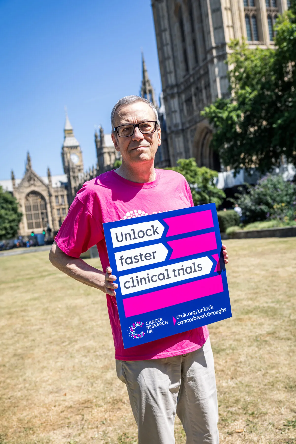 Man holding a sign that says unlock faster clinical trials.