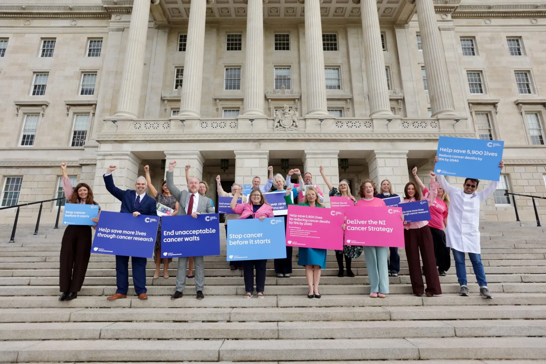 People holding colourful sins outside Stormont