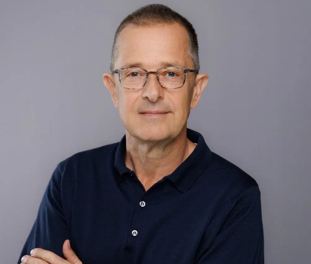Image of a man with glasses against a grey background